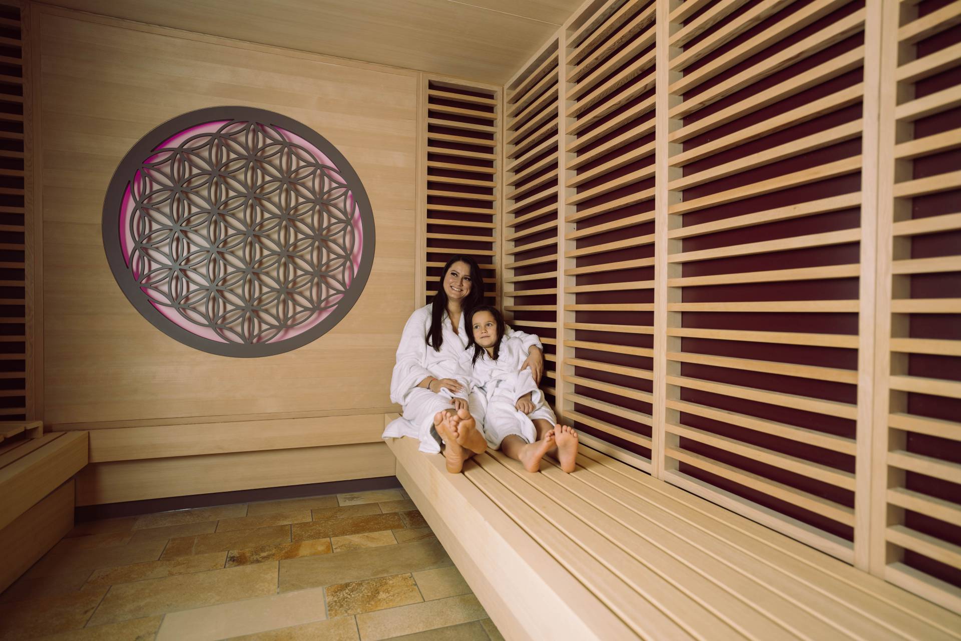 Mama und Tochter im Bademantel in der Infrarotsauna