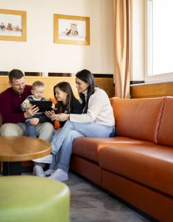 Familie am Tablet im Hotelzimmer