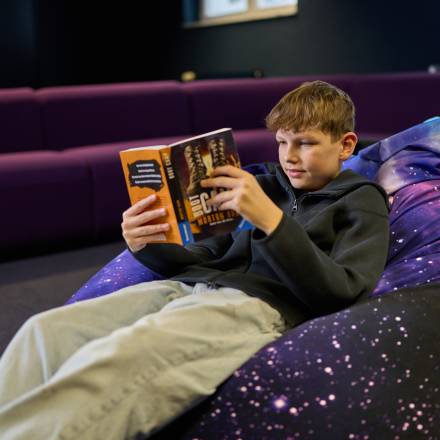 Ein Tennie liest ein Buch im Sitzsack