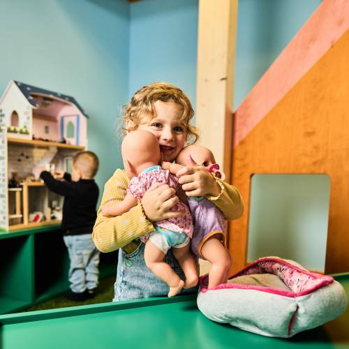 Kinder spielen in der Puppenecke