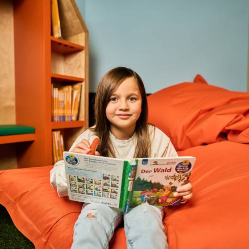 Mädchen liest Buch in Sitzsack