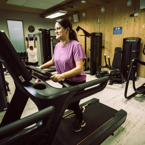 Eine Frau auf dem Laufband im Fitnessraum des Feldberger Hof
