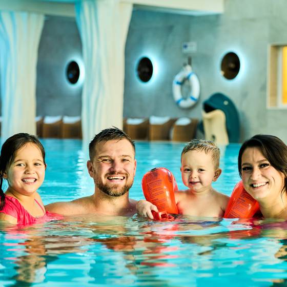 Mama, Papa, Tochter und Sohn sind im Pool des Feldberger Hof