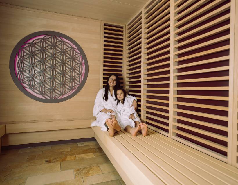 Mama und Tochter im Bademantel in der Infrarotsauna