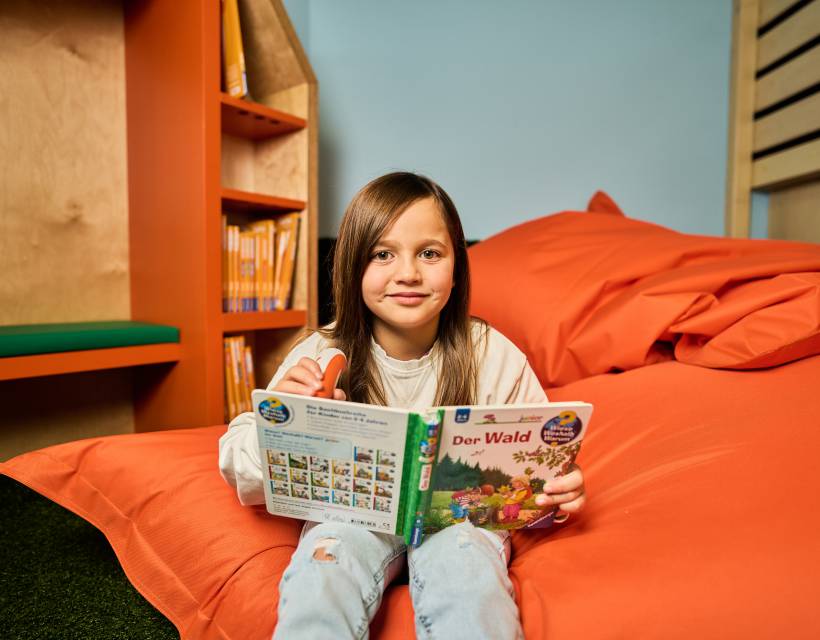 Mädchen liest Buch in Sitzsack