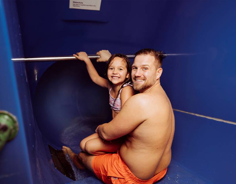 Papa mit Tochter auf der Wasserrutsche