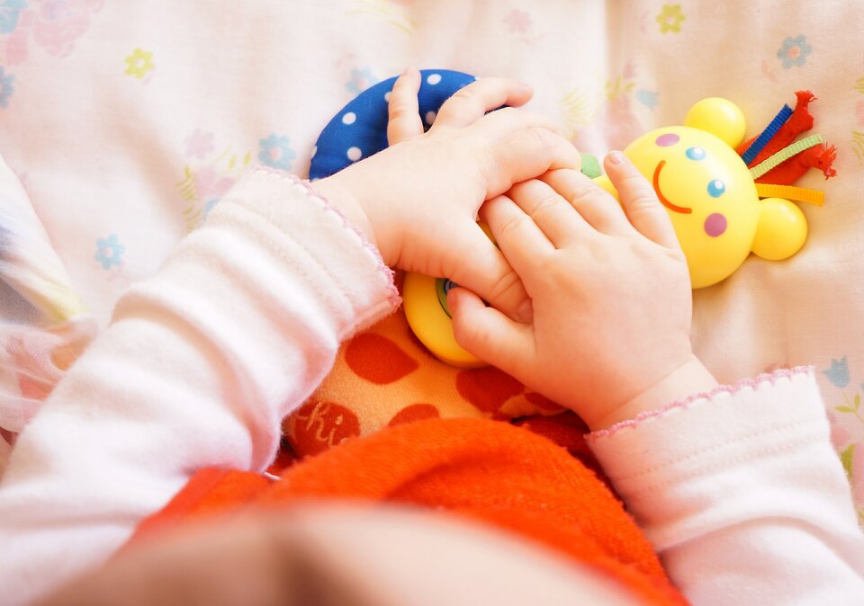 Babyhände halten Spielzeug