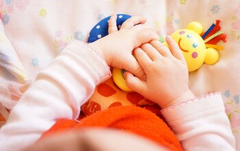 Babyhände halten Spielzeug