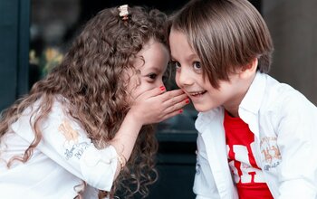 Kinder flüstern sich was zu