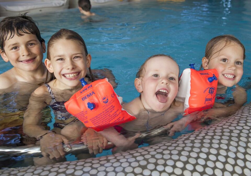Kinder planschen am Poolrand