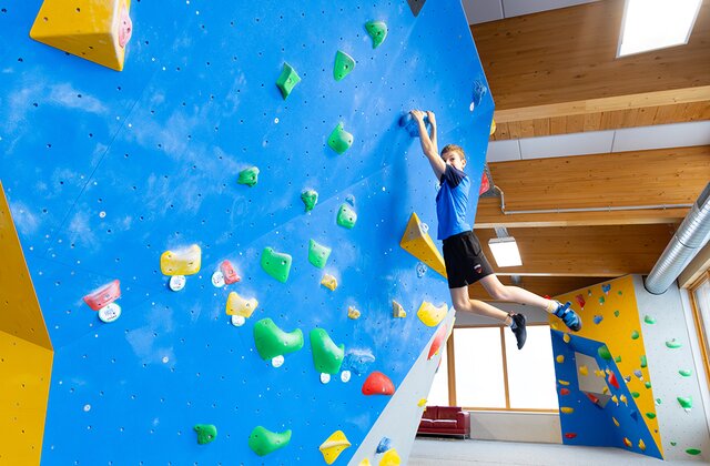 Kinder klettern auf der Boulderwand