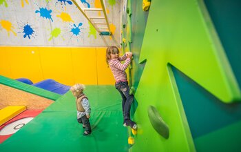 Kinder klettern auf der Wand