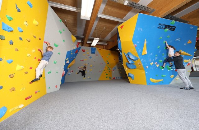 Kinder klettern auf der Boulderwand