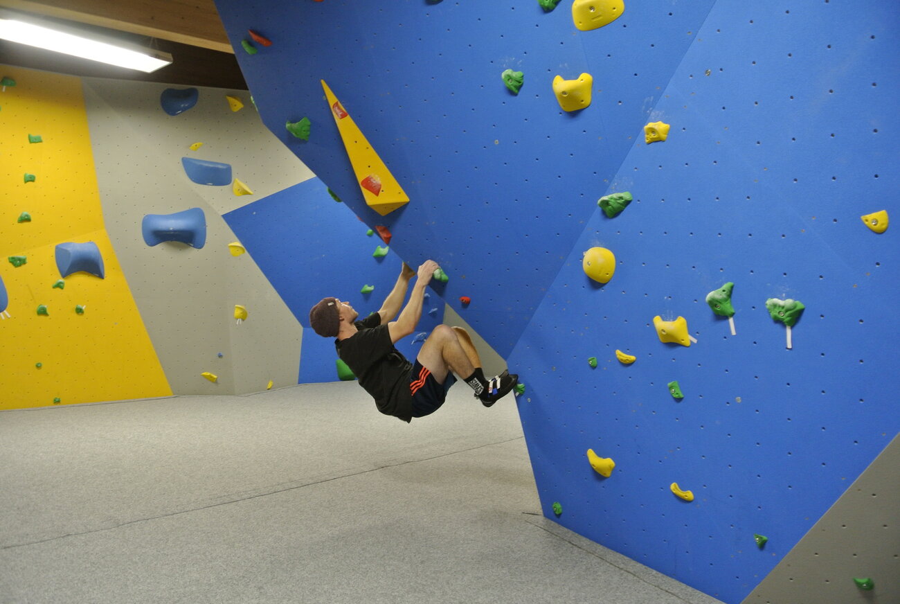 Teenager klettert auf Boulderwand
