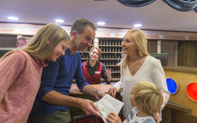 Familie beim Check-in an der Rezeption