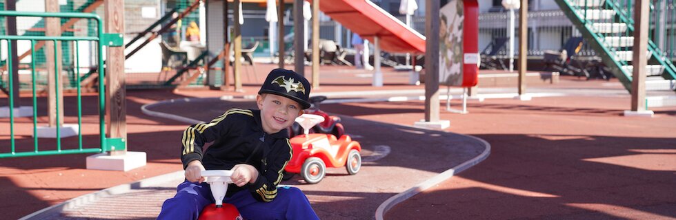 Junge fährt Bobbycar am Kleinkinder-Spielplatz