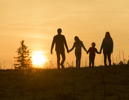 Familie wandert im Sonnenuntergang